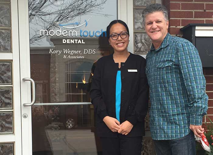 Couple standing outside modern touch dental clinic